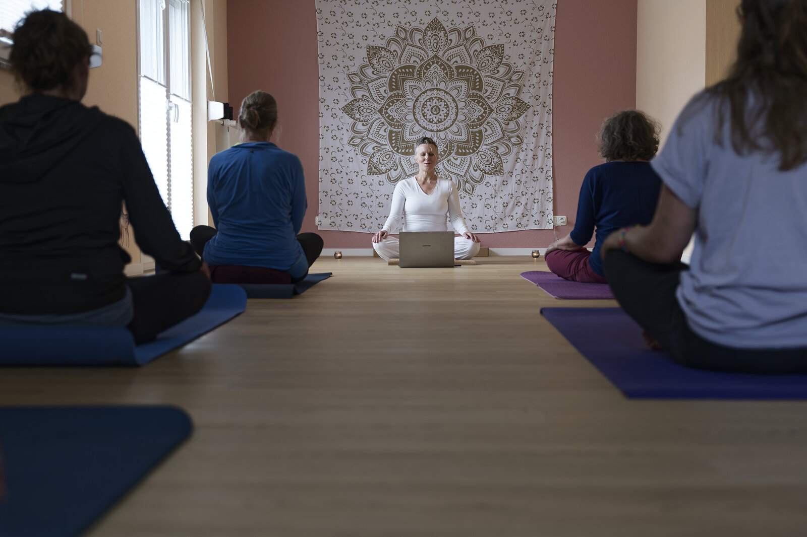 Hatha-Yoga-Stunde — Klasse im Kursraum vor dem Mandala